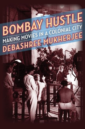 Book cover of pink-white text against a photo of an old movie set. Title: Bombay Hustle: Making Movies in a Colonial City.