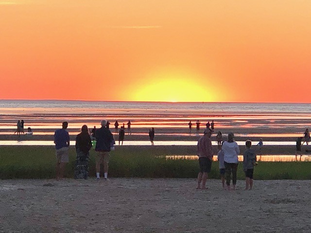 The sun rises over Cape Code beach and the Atlantic ocean. 