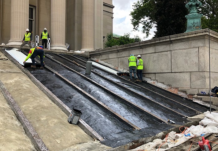 Workers pave the undergirding for Low Library steps with tar and sheeting. 