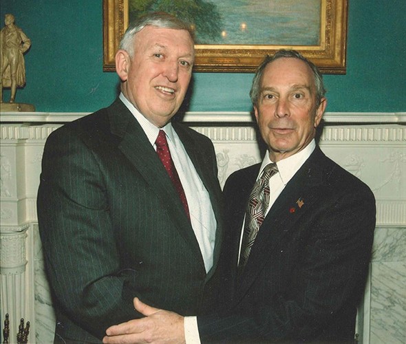Two men holding each other standing up and facing the camera
