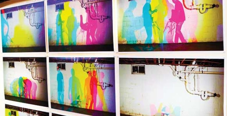 Brightly colored murals with shadows of men and women walking