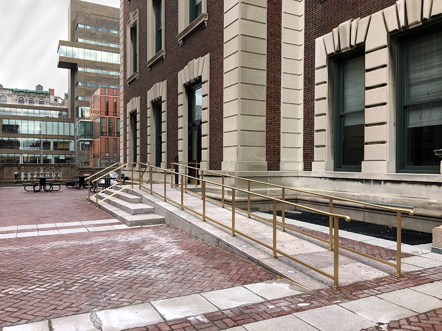 A masonry ramp with bronze handrails leads up to the entrance of the brick-building, Havermeyer.