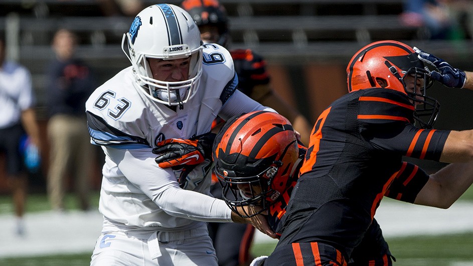 Patricky Eby, number 63, on the Columbia football team stopping an opponent. 
