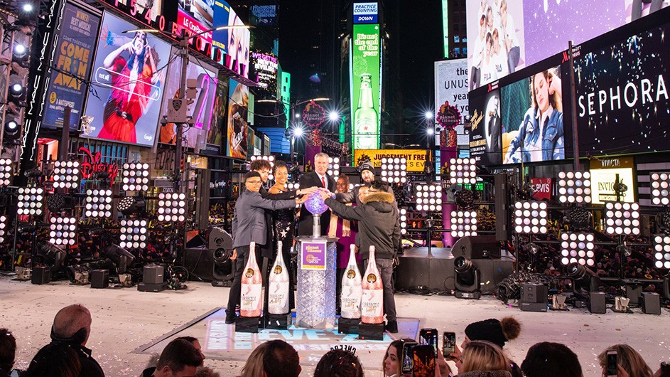 NYC Mayor Bill de Blasio and First Lady Chirlane McCray stand on a platform in the middle of Times Square with teachers Jared Fox and Aida Rosenbaum accompanied by two students each. 