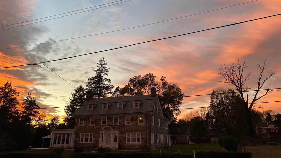 A photo of a sunset and a red brick house