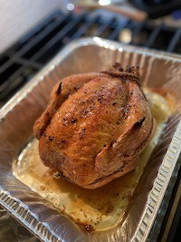 An image of a roast chicken in an aluminum pan