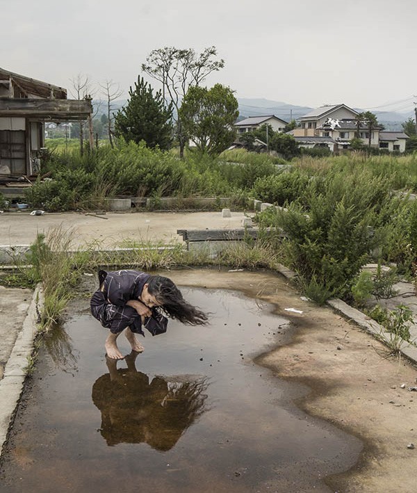 Woman kneeling in water on an empty foundation