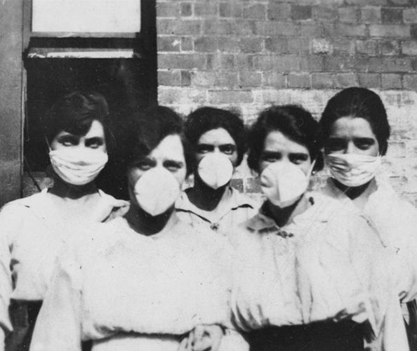five women with black hair wearing white face masks and white shirts at turn of century