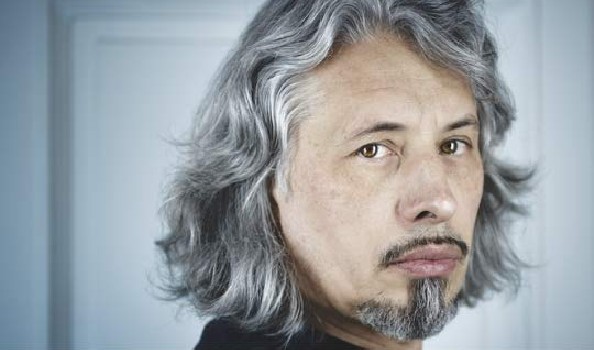 A man with goatee and long grey hair looking into the camera
