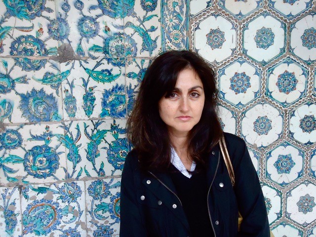 Zainab Bahrani against a blue patterned tiled background