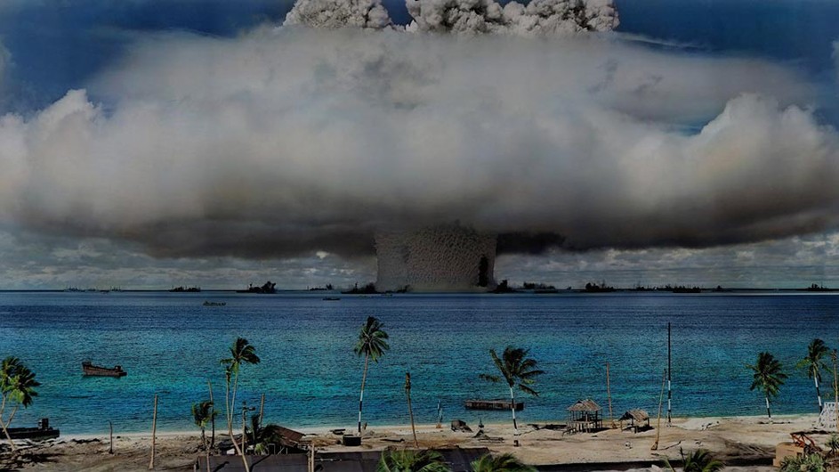 A fiery nuclear explosion over the blue water and palm trees of Marshall Island