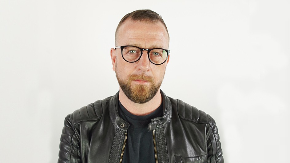 Matthew Hart: a man with glasses and a beard, wearing a black shirt and black leather jacket.