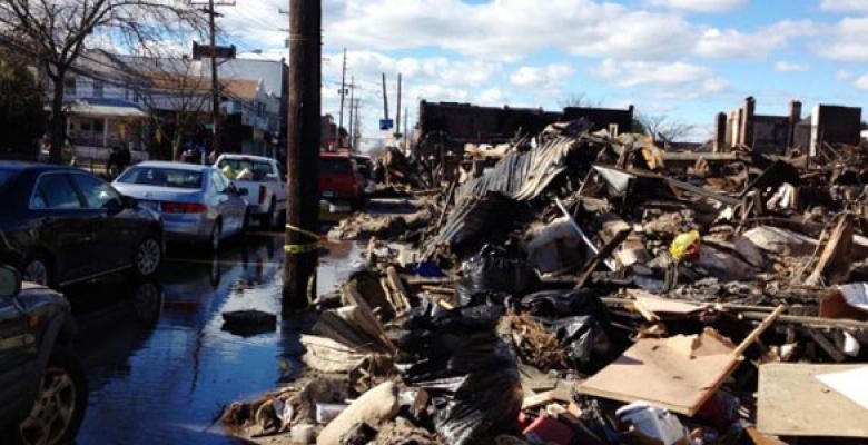 wreckage of buildngs and cars as a result of Hurricane Sandy with buildings in the far distance