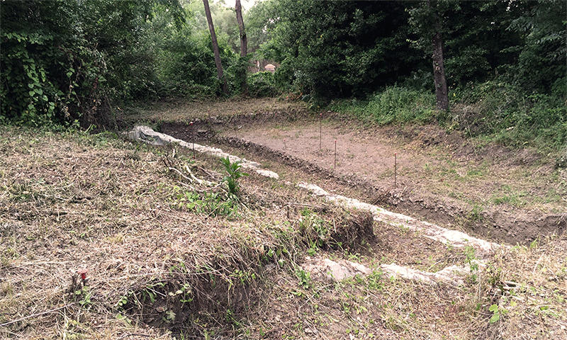 A grassy knoll becomes an excavation site with walls