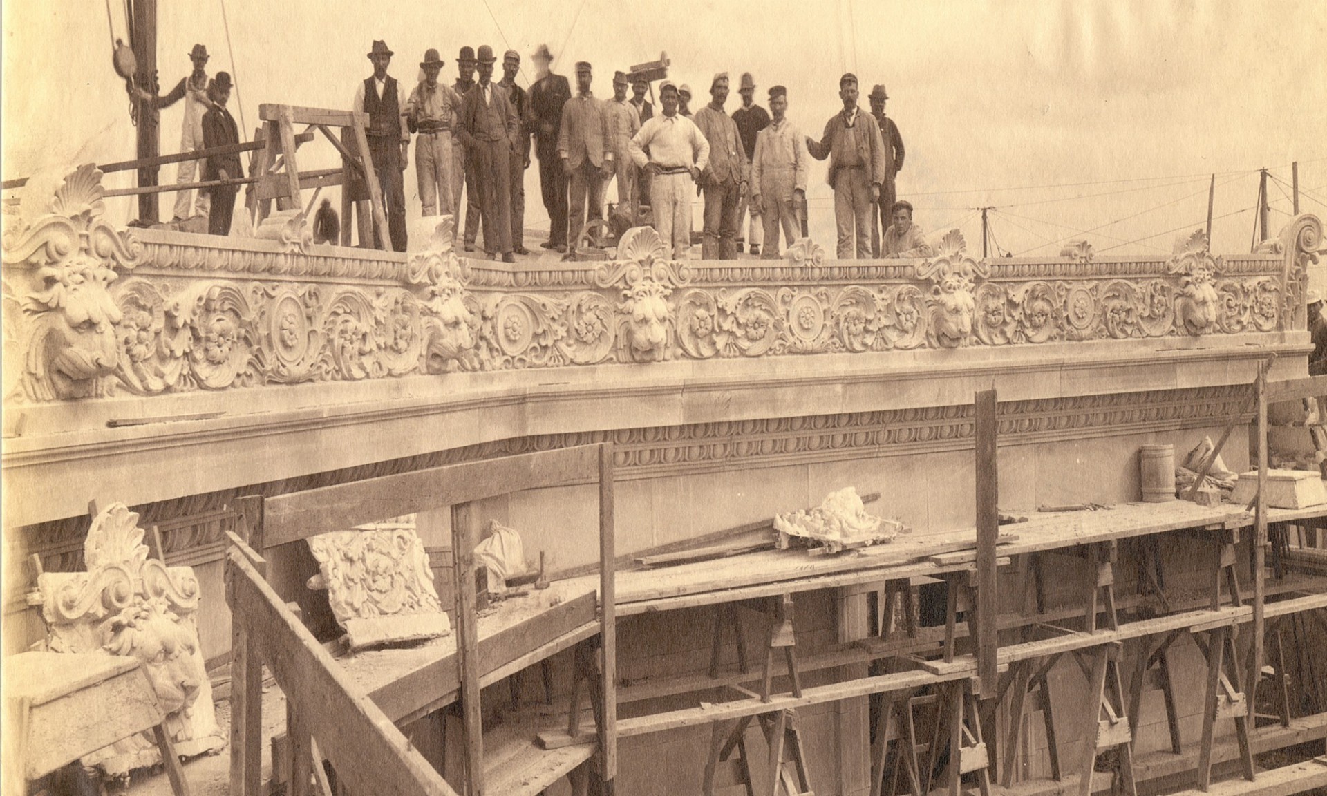 sepia toned vintage image of work men standing on an exposed portion of the under construction low library