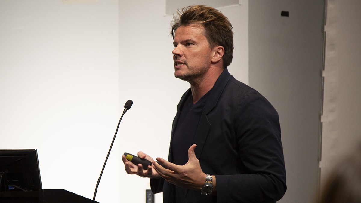 Architect Bjarke Ingels speaks about his practice at the Graduate School of Architecture, Planning and Preservation. A wearing a dark shirt and jacket standing behind a lectern.