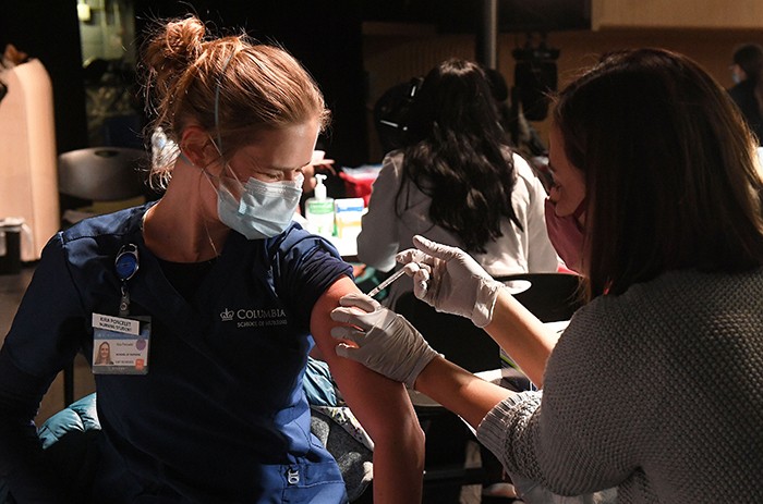 A nurse gets a Covid-19 vaccine in January. 