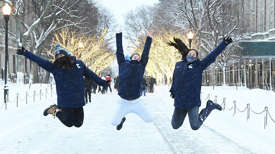 Sixteen inches of snow blanketed New York City in February 2021, which was cause for a little snowy fun on campus. Photo by Eileen Barroso. Three Columbia students jump in the snow on College Walk in February.