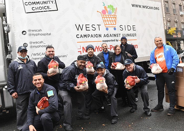 A group of Columbians stand with the west side campaign against hunger holding turkeys