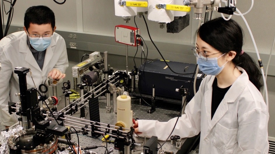 Columbia University graduate students Lin Xiong (left) and Yinan Dong image polaritons using a cryogenic microscope. (Credit: Yinan Dong)