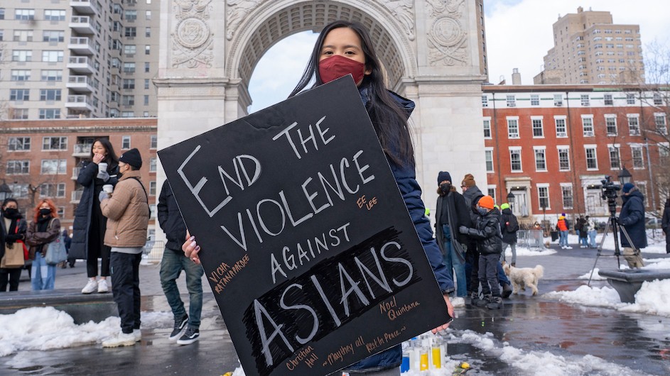 Asian American woman with a sign 