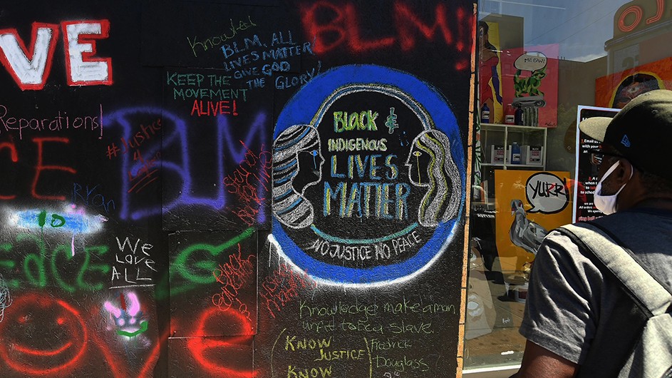 Photo by Eileen Barroso A man looks at street art reading "Black and indigenous LIVES MATTER"