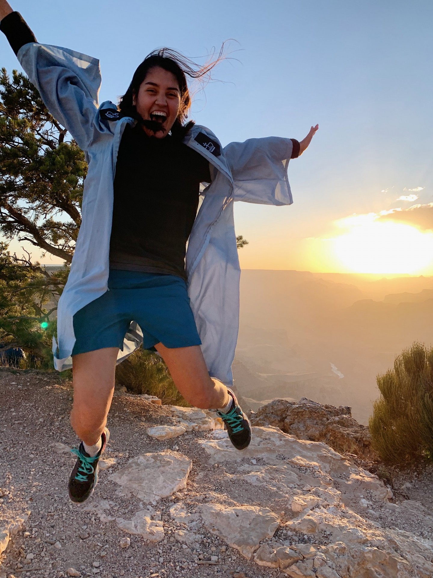 Celia Orduna jumps in Commencement regalia on the rim of the Grand Canyon.