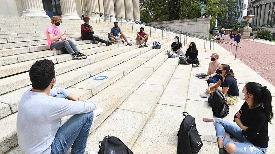 Students sit in a socially-distanced circle on Low Steps for class. 