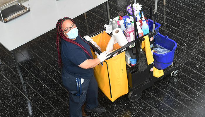 A Columbia Facilities worker with a cleaning cart. 