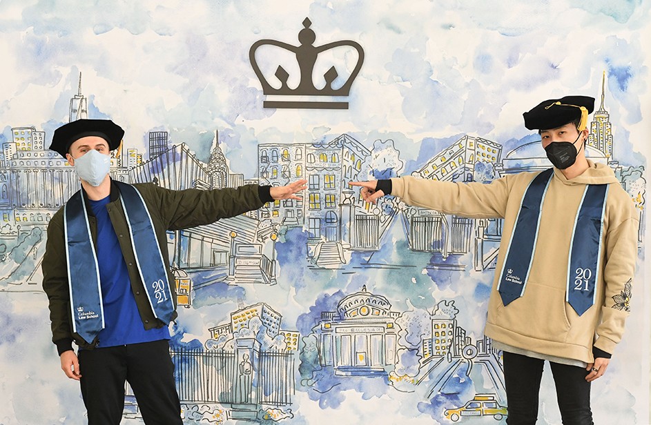 Photo by Eileen Barroso Two Columbia Law grads point ot a graphical representation of Columbia.