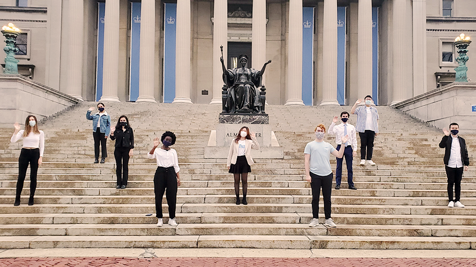 A Columbia singing group stands six feet apart on the steps of Low Library. 