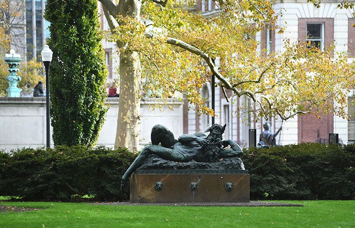 The statue of Pan on Columbia's campus under fall foliage.