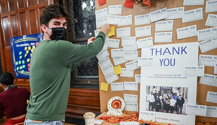 A male student posts a thank you to the Columbia dining staff in John Jay