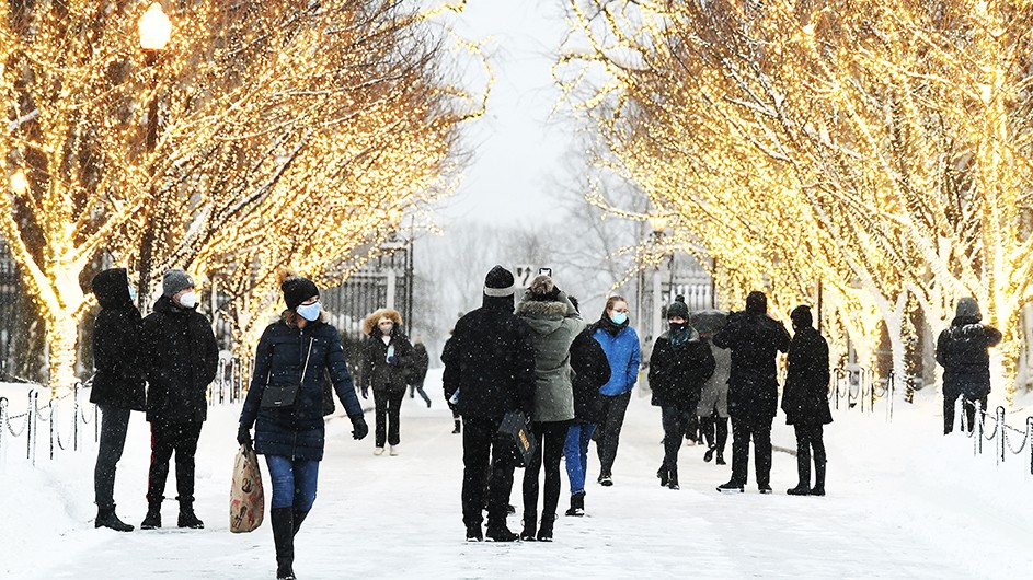 Photo by Eileen Barroso Visitors in masks revel in the College Walk holiday lights.