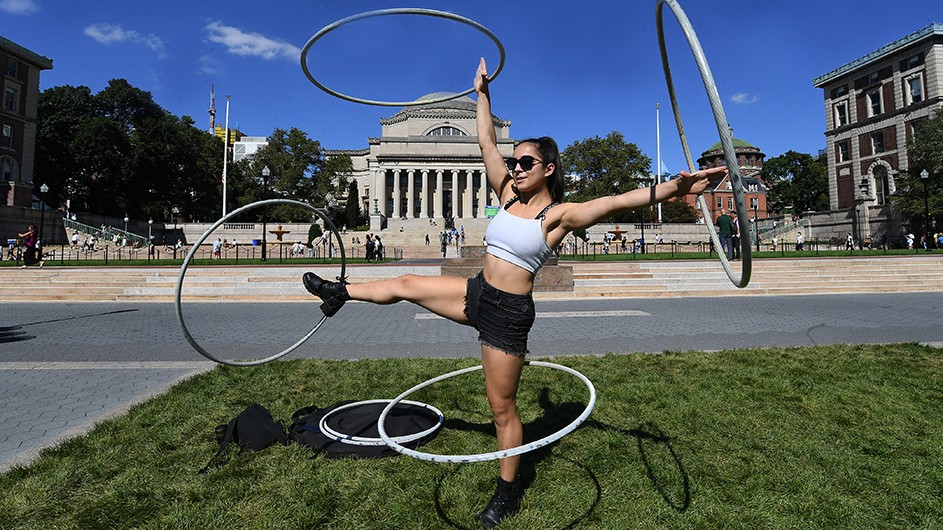 Maia Oceana Castro-Santos spins four hula-hoops around her legs and arms on Butler Lawn. 