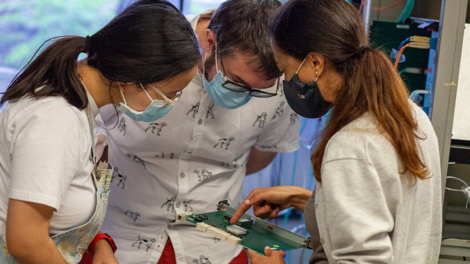 An electronics board at Nevis Labs with Columbia University's Guanqun Ge, Mark Ross-Lonergan, and Georgia Karagiorgi