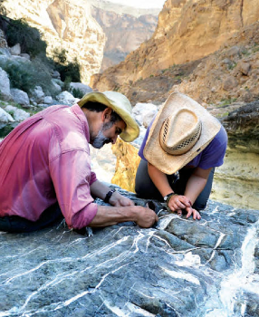 Columbia researcher Peter Kelemen, left, examines rocks in Oman with carbonate veins. (Photo: Kevin Krajick) Columbia researcher Peter Kelemen examines rocks in Oman with carbonate veins. (Photo: Kevin Krajick)