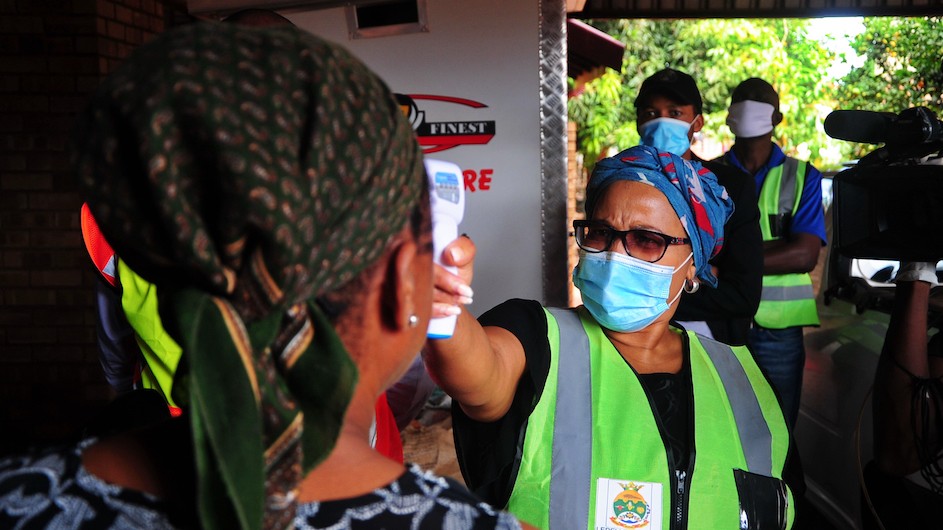 Community healthcare workers conduct door to door screening for COVID-19 in South Africa. Photo credit: Mukurukuru Media/Shutterstock Healthcare workers in South Africa taking temperatures to test for signs of COVID