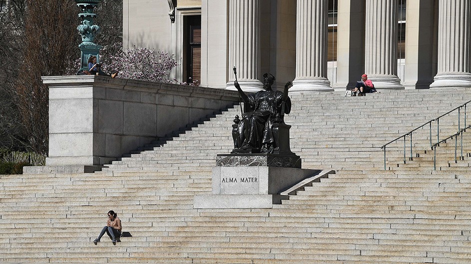 Two students sit on the abandoned Low Steps following the shutdown of Columbia's campus due to COVID-19. Photo by Eileen Barroso. A student sits alone on Low Steps at Columbia.