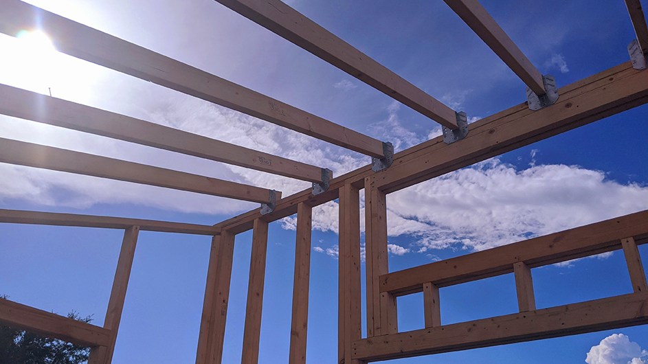 The beams of a tiny home against the sky.