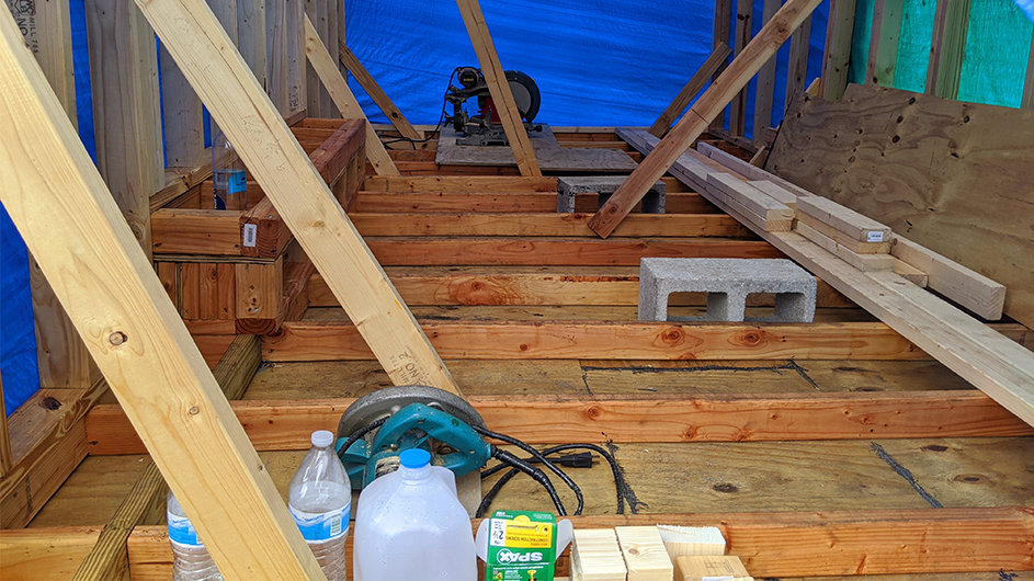 The floor of a tiny home, only wood and concrete.