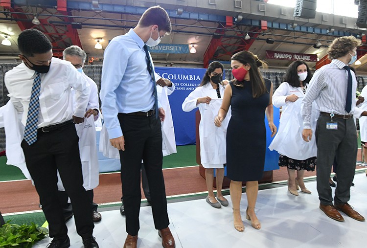 The white coat ceremony at Vagelos College of Physicians and Surgeons. Photo by Eileen Barroso. Students have white coats put on them by doctors at Armory Track and Field Center