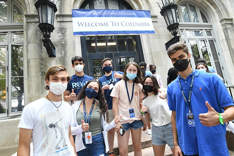 Photo by Eileen Barroso students stand in front of a Columbia residence hall