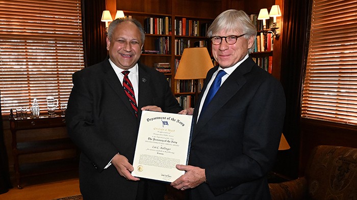 Secretary of the U.S. Navy Carlos Del Toro presents President Lee C. Bollinger with the Naval citation.