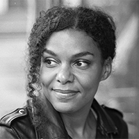 A woman with pulled back hair, in black and white. 