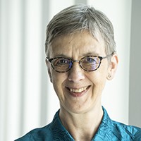 A woman with short grey hair and glasses. 