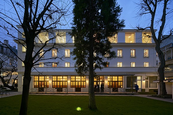 The Institute for Ideas and Imagination at Reid Hall, home to Columbia Global Centers | Paris. Photo: Michel Denancé. A building at Reid Hall in Paris, at twilight. in front of a green lawn.