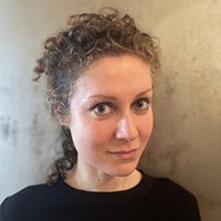 Yasmine Seale A woman with light hair, pulled back, in a black top.