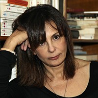 A woman with medium-length dark hair, in a black top