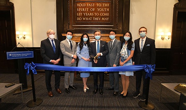 President Lee C. Bollinger, the Wang Family, and Columbia College Dean James Valentini gather to open the renovated Walter and Shirley Fan (BUS'93) Wang Lounge. Photo: Eileen Barroso A group of seven people in suits and dresses, masked, gather around for a ribbon-cutting.